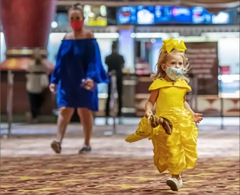  ?? Steph Chambers/Post-Gazette ?? Dressed as Disney's Belle, Lilly Stevenson, 3, of McMurray, holds her Belle doll as she makes her way to see "Beauty and the Beast" during AMC Waterfront movie theater's reopening Thursday in West Homestead.