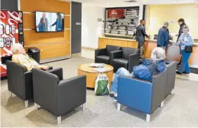  ?? STAFF PHOTO BY JOHN RAWLSTON ?? Customers relax in the waiting area at the newly remodeled Integrity Buick GMC Cadillac dealership on Internatio­nal Drive.