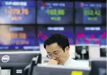  ?? AHN YOUNG- JOON/ THE ASSOCIATED PRESS ?? A currency trader works at the KEB Hana Bank in Seoul on Thursday. Risk is a personal thing that means building the right portfolio to fit your needs, says Tom Bradley.