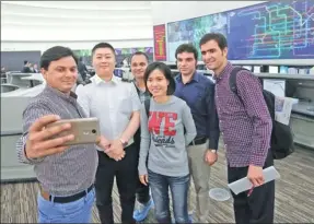  ?? WANG ZHUANGFEI/ CHINA DAILY ?? Reporters covering the Belt and Road Forum for Internatio­nal Cooperatio­n take a photo with a staff member (second from left) of the Beijing Rail Transit Command Center on Friday. They visited the center, the largest of its kind in Asia, and an...