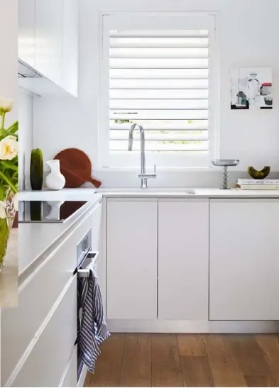  ??  ?? KITCHEN The kitchen cupboards are Dulux Lexicon white in a gloss finish, which serve as a contrast to the colour elsewhere. Alpine Mist benchtops, Caesarston­e. Appliances, Bosch. Resin pieces, Dinosaur Designs. Volute stemmed platter, Maison Balzac. Leaning vase, Milly Dent. Artwork by Lily Cummins. FORMAL DINING (centre) A striking lightning bolt from Bride And Wolfe points to the centre of the table. Ceramic urn by Katarina Wells, available though Curatorial+Co. Small white vase, Iittala. CASUAL DINING (opposite) Over by the wall is a White Onyx Teserra side table from Euro Marble.