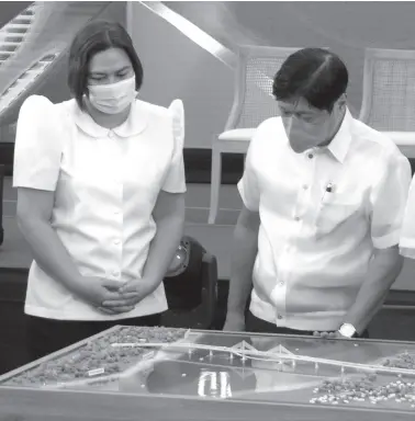  ?? BING GONZALES ?? PRESIDENT Ferdinand Marcos Jr. and Vice President Sara Duterte check on the model of the proposed Davao City - Samal Island bridge project during the groundbrea­king ceremony in Lanang on October 27.