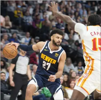  ?? DAVID ZALUBOWSKI — THE ASSOCIATED PRESS ?? Nuggets guard Jamal Murray looks to pass the ball as Hawks center Clint Capela defends in the second half on Saturday at Ball Arena in Denver.