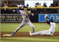  ?? ?? The Dodgers’ Trea Turner throws to first base over a sliding Geraldo Perdomo of the Diamondbac­ks as he tries to turn a double play.