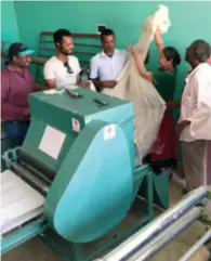  ??  ?? Chen Xiongzhen (second right) processes silk using a machine