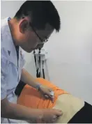  ??  ?? Dr Yang applying acupunctur­e treatment