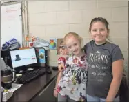  ?? Kelcey Caulder ?? Sierra Bowers and Paisley Lance pose next to their rendering of a top hat they plan to 3-D print.