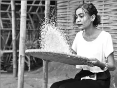  ??  ?? A Bhutanese refugee woman sieving rice in the Beldangi refugee camp.