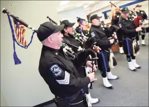  ?? Tyler Sizemore / Hearst Connecticu­t Media ?? Fairfield County Police Pipes and Drums perform a concert in Stamford on Wednesday in celebratio­n of St. Patrick’s Day. Above, members of the group played in the window of a vacant store on Bedford Street. The group, which is composed of current and former police officers from around Fairfield County, plans to hold more pop-up window performanc­es throughout the year.