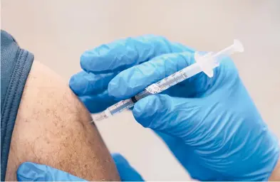  ?? PAUL SANCYA/AP ?? A health care worker receives a second COVID-19 vaccine shot Tuesday at Beaumont Health in Southfield, Michigan.