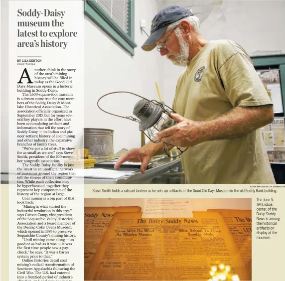  ?? STAFF PHOTOS BY C.B. SCHMELTER ?? Steve Smith holds a railroad lantern as he sets up artifacts at the Good Old Days Museum in the old Soddy Bank building .The June 5, 1941, issue, center, of the Daisy-Soddy News is among the historical artifacts on display at the museum.