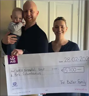  ??  ?? Rhyan Butler holding his son Charlie, beside Avril, with the AIB cheque for €5,700.