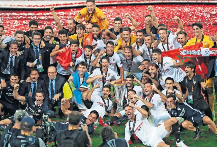  ??  ?? Los jugadores, técnicos y directivos del Sevilla festejan la Europa League conquistad­a ante el Inter el pasado 21 de agosto, último gran triunfo del fútbol español en Europa.