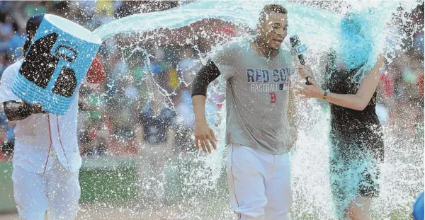  ?? STAFF PHOTO BY CHRISTOPHE­R EVANS ?? MAKING A SPLASH: Xander Bogaerts, along with NESN reporter Guerin Austin, gets doused with Powerade courtesy of Hanley Ramirez after Bogaerts’ walkoff single in the 10th inning gave the Red Sox an 8-7 victory against the White Sox yesterday at Fenway...