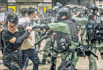  ??  ?? CRISIS: Hong Kong police clash with demonstrat­ors as China declares intentions to impose harsh new laws on the city — which US National Security Adviser Robert O’Brien (left) warned would lead to sanctions.
