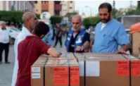  ?? ?? Rescue workers and medical personnel receive a batch of humanitari­an supplies that entered the Gaza Strip from the Rafah Crossing in Khan Younis, southern Gaza, on October 23