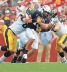  ?? DAVID PURDY/GETTY IMAGES ?? Logan Lee and Seth Benson stop another QB. Iowa is 7th nationally in team sacks (13).