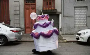  ?? — aFP ?? Cake walk: a ‘cake’ walking along a street in Montevideo, uruguay, after being delivered to a girl for her birthday. The idea came from a man who began a quarantine­d birthday business amid Covid-19 curbs.