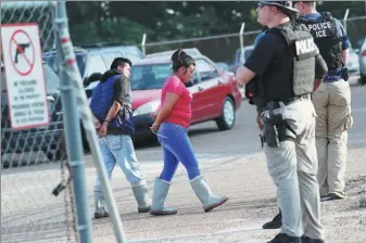  ??  ?? Two people are taken into custody at a Koch Foods plant in Morton, Mississipp­i, on Wednesday.