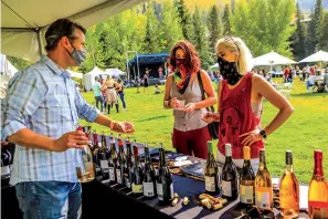  ?? Chris Dillmann/Vail Daily via AP ?? ■ Jeremy Reimann of Foley Family Wines pours a sample for Kate Poueymirou, left, of Denver and Katie Budge of New Orleans during the Wine Classic of Vail Friday in Vail, Colo. The socially distanced event featured multiple tasting sessions to keep crowds down at each tasting.