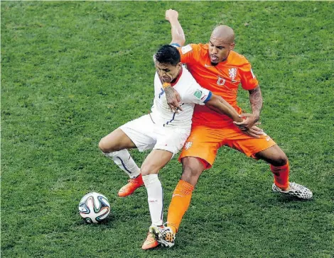  ?? T h a nass i s Stav r a k i s/ t h e ass o c i at e d p r e ss ?? Chile’s Alexis Sanchez, left, and Netherland­s’ Nigel de Jong battle for the ball during the 2-0 Dutch win in Group B action.