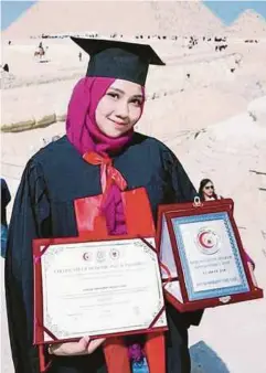  ??  ?? SYAFIQA Hayra bersama Ijazah Sarjana Muda Perubatan yang baru diterimany­a.