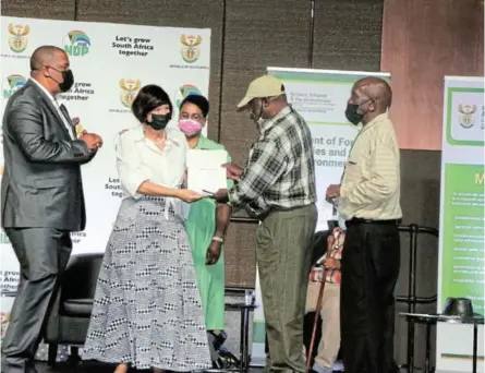  ?? / SUPPLIED ?? Minister Barbara Creecy, with chief land claims commission­er Nomfundo Ntloko-Gobodo, handing over a title deed to one of the land claimants present at the ninth People and Parks Conference.