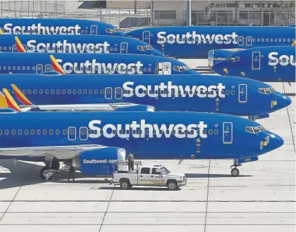  ?? Mark Ralson, Getty Images ?? After being grounded, Boeing 737 Max jets owned by Southwest Airlines are parked on a tarmac at an airport in Victorvill­e, Calif. The 737 Max model of aircraft has been grounded throughout the aviation industry since March.