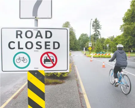  ?? MIKE BELL ?? A cyclist enters Stanley Park along Beach Avenue on Thursday. The number of cyclists entering the park has soared since cars were temporaril­y banned back on April 8, but a push by the park board to permanentl­y reduce motor vehicle traffic is riling business owners and drivers alike.