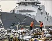  ?? FAUZY CHANIAGO / ASSOCIATED PRESS ?? Searchers at Tanjung Priok Port in Jakarta, Indonesia, on Wednesday inspect debris retrieved from waters where Lion Air Flight JT 610 is believed to have crashed, killing all 189 people on board.