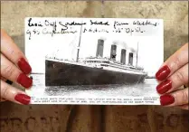  ?? MICHAEL CRABTREE / BLOOMBERG ?? A postcard of the Titanic is displayed at Christie’s in London in 2007. Premier Exhibition­s holds the rights to the ship and 5,500 Titanic artifacts.