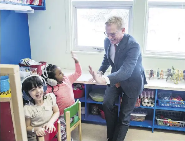  ?? SHAUGHN BUTTS ?? Ecole a la Decouverte Grade 2 students Reem Bakkich and Asthma Waberi celebrate with Education Minister David Eggen Friday after he announced a new facility had been approved for the francophon­e school. The school has moved three times in the past...