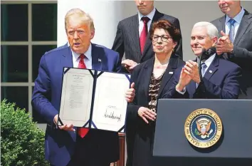  ?? AP ?? US President Donald Trump shows his signature on the Paycheck Protection Program Flexibilit­y Act of 2020 at the White House yesterday.