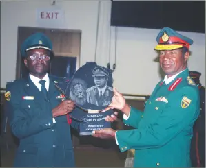  ?? — Picture by ?? Commander Zimbabwe National Army Lieutenant-General Philip Valerio Sibanda receives a token of appreciati­on from Major Victor Makomo after the Logistics Staff Course Number Four graduation ceremony held at the Zimbabwe Staff College in Harare yesterday.