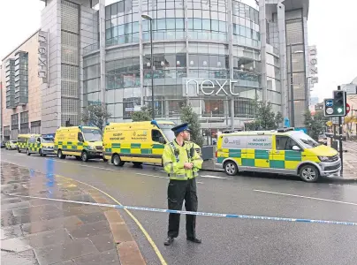  ??  ?? RESPONSE: Police and ambulances outside the Arndale Centre in Manchester after three people were stabbed