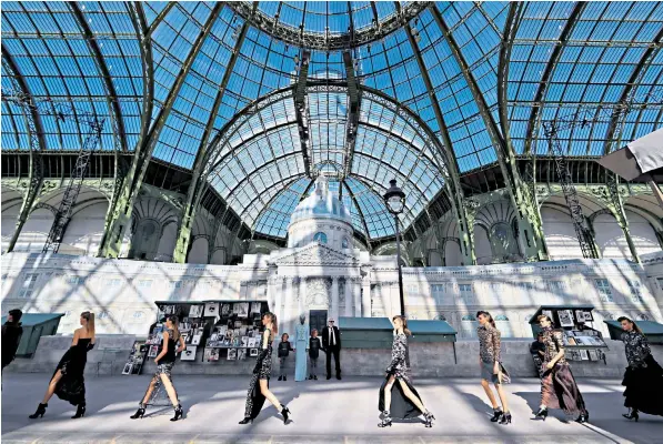  ??  ?? Karl Lagerfeld, the designer, appears with Hudson Kroenig and other models at the end of his show for Chanel in Paris, complete with a street scene featuring bouquinist­es, the fold-up book stalls still seen along the Seine