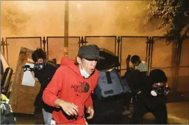  ?? MARCIO JOSE SANCHEZ — THE ASSOCIATED PRESS FILE ?? Demonstrat­ors back away from tear gas during a Black Lives Matter protest at the Mark O. Hatfield United States Courthouse on July 23, 2020, in Portland, Ore.