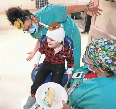  ??  ?? Westyn Tudor, 3, hangs out with his occupation­al therapists, Andria Martinez (top) and Renee Warthman, during a party for Westyn heading home, at the burn unit at Valleywise Health Medical Center in Phoenix.