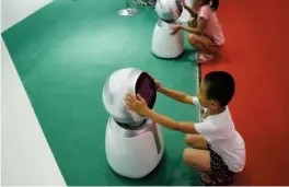  ?? — AFP ?? Children play with robots at the 2018 World Robot Conference in Beijing.