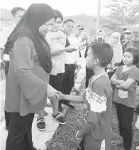  ??  ?? MAIMUNAH menyantuni dan memberikan kata-kata semangat dan perangsang kepada murid-murid yang terlibat sebagai mangsa kebakaran di kampung mereka.