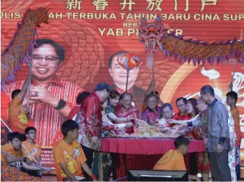  ?? ?? Abang Johari (centre) and other guests perform the Yee sang tossing ceremony.