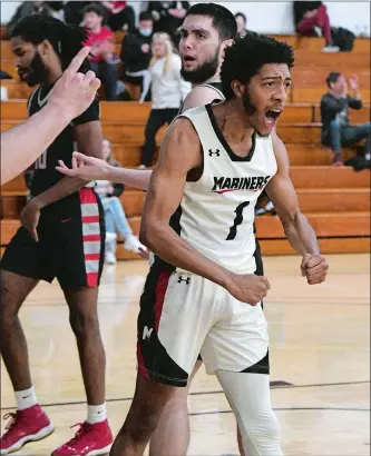  ?? DANA JENSEN/THE DAY ?? Mitchell College’s Alfonzo Stokes (1) reacts after making a basket and being fouled by Eastern Nazarene’s Isaac Padilla (25 in background) during Saturday’s NECC men’s basketball game in New London. Stokes scored the 1,000th point of his career as the Mariners rolled to a 98-84 victory.