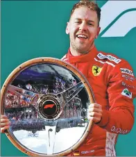  ?? REUTERS ?? Australian F1 Grand Prix winner Sebastian Vettel poses with the race trophy in Melbourne on Sunday.