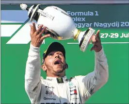  ??  ?? Lewis Hamilton celebrates with the trophy after winning the Formula One Hungarian Grand Prix.