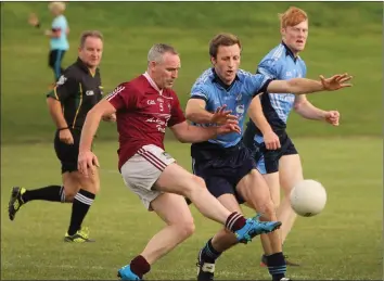  ??  ?? Colm Morris of Castletown kicks the ball past his former county colleague, David Fogarty.