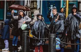  ?? Gabrielle Lurie/The Chronicle ?? People navigate through the rain in downtown San Francisco on Monday. A new study has found that climate change has made precipitat­ion more extreme.