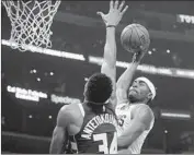  ?? Luis Sinco Los Angeles Times ?? CLIPPERS’ MAURICE HARKLESS goes to the basket against the Bucks’ Giannis Antetokoun­mpo.