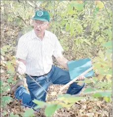  ?? Keith Bryant/The Weekly Vista ?? Retired USDA scientist Calvin Bey uses some uncleared ground near the Kingsdale golf complex to demonstrat­e that covered soil is far healthier.