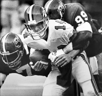  ?? Associated Press ?? Maulers Sam Clancy, left, and Doug Hollie sack Oakland Invaders quarterbac­k Fred Besana in one of the Maulers’ three wins in their one and only season in 1984.