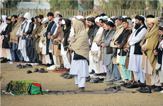  ?? JAVED TANVEER / AFP / GETTY IMAGES ?? Afghan mourners offer funeral prayers to Mufti Ahmad Farzan, a member of the High Peace Council, who died during an attack by armed insurgents at Kabul’s Interconti­nental hotel, in Kandahar province on Monday.